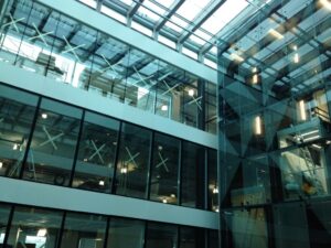 Innvendig atrium med store glassvinduer og tak i moderne bygg.