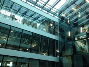 Innvendig atrium med store glassvinduer og tak i moderne bygg.
