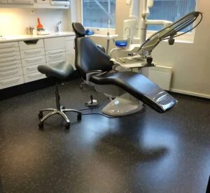 Tannlegestol med tilhørende utstyr i moderne klinikkrom.