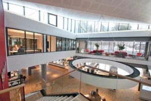 Moderne kontorbygg med store vinduer, trapper og åpen lounge.