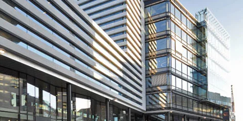 Moderne kontorbygg med glassfasader og horisontale linjer i dagslys
