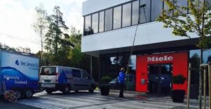 Fasadevask utføres med langt skaft foran Miele-bygning og firmabil
